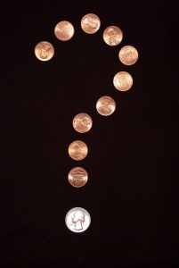 A question mark made with pennies and quarters.