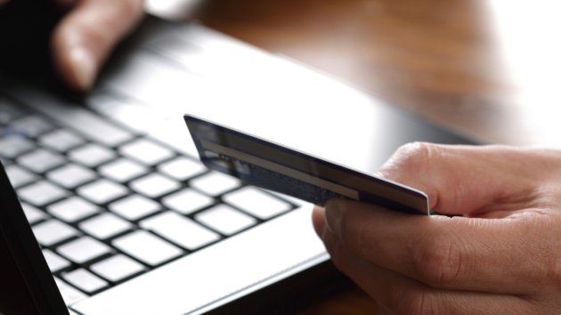 Hand with credit card on computer