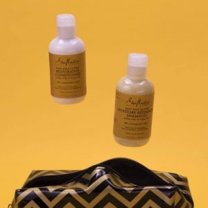 Two Shea Moisture products jump out of a gold and black striped bag.