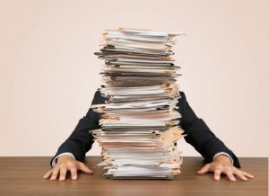 man overwhelmed by paperwork