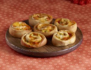 Amy's Cheddar Jalapeno Swirls on a brown plate. The plate sits on a red floral tablecloth.