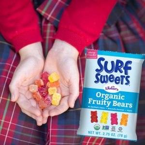A girl holds Surf Sweets Organic Fruity Bears in her cupped hands