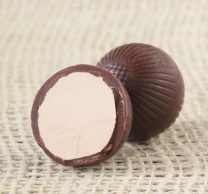 A single Alter Eco Dark Mint Truffle, cut open to display the creamy mint center