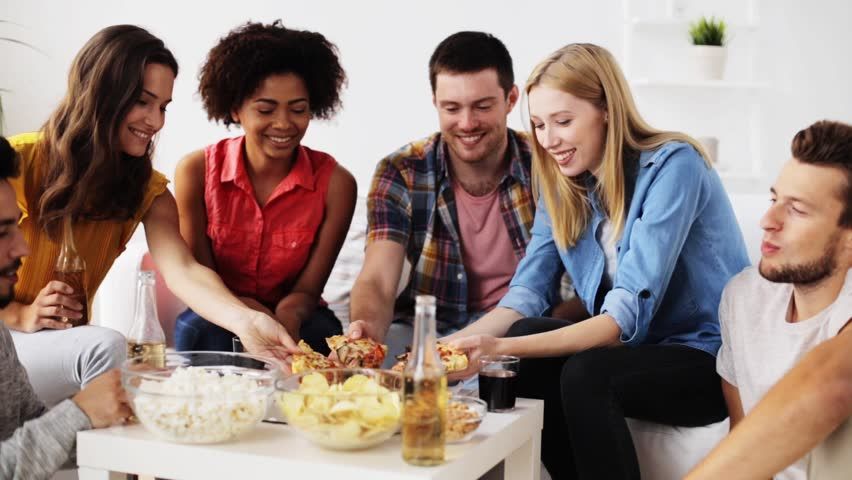 people gathered around a table eating snack foods