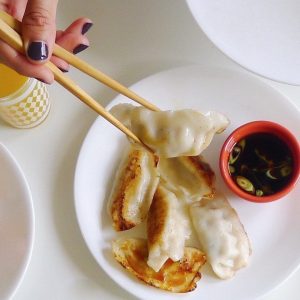 pork potstickers with sauce and chopsticks
