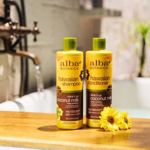 Alba Botanica Shampoo and conditioner (coconut milk) products sit by a bathtub