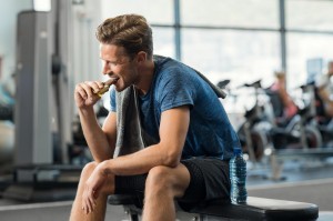 a man eating a chocolate protein bar 