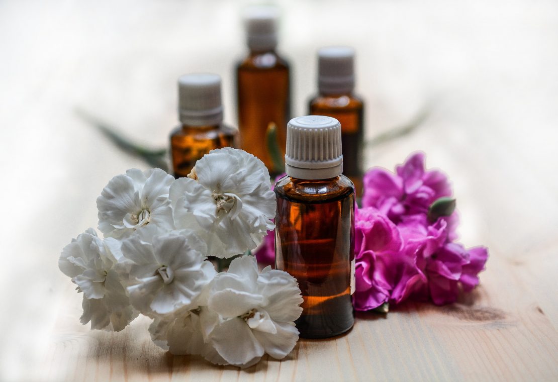 Bottles of essential oil and flowers 