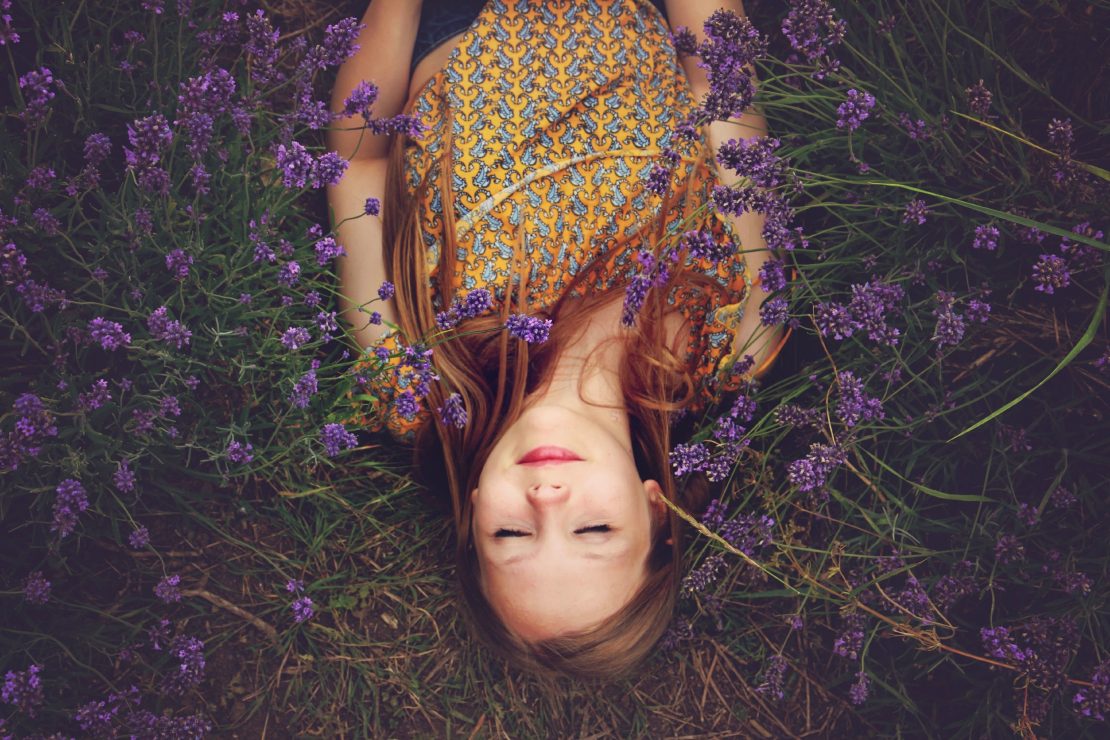 Girl lying in field of lavender flowers