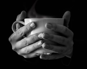 black and white hands holding teacup