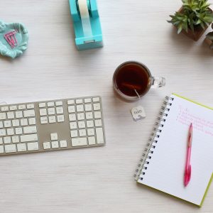 An Image Containing a keyboard, Notebook and a Cup of Coffee