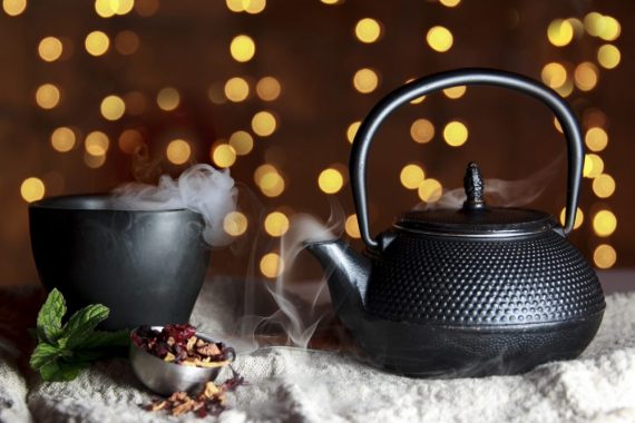 Steaming teapot and cup of organic tea