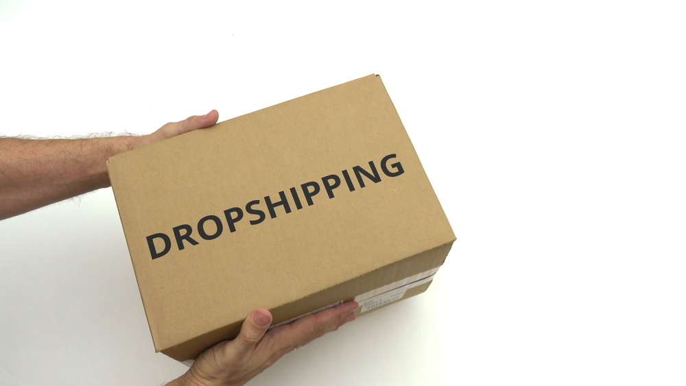 Man delivering box with dropshipping written on it.