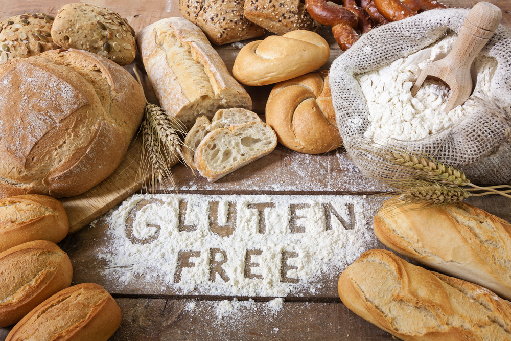 Wholesale flour and breads on a wood surface with gluten free written in flour