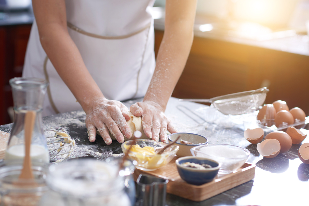 baker's hands making dough in kitchen. Wholesale baking ingredients to sell online.