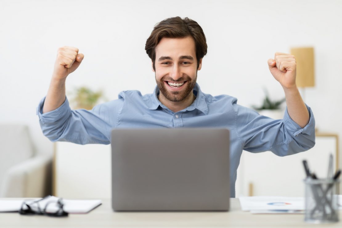 Man cheering at computer - Facebook marketing dropshipping success stories