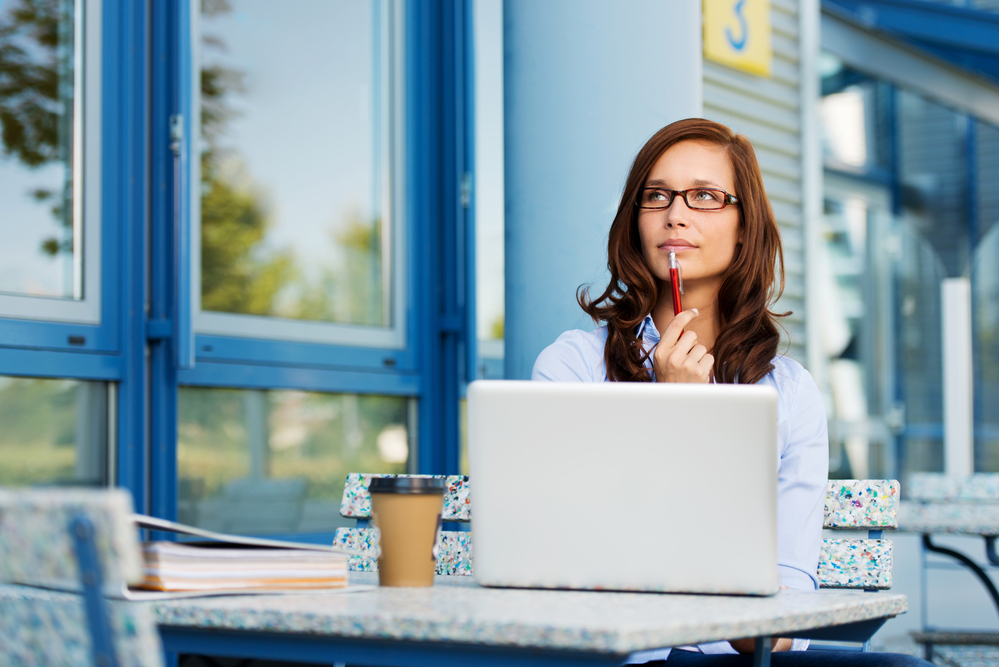 woman thinking in front of her laptop. developing a unique selling proposition