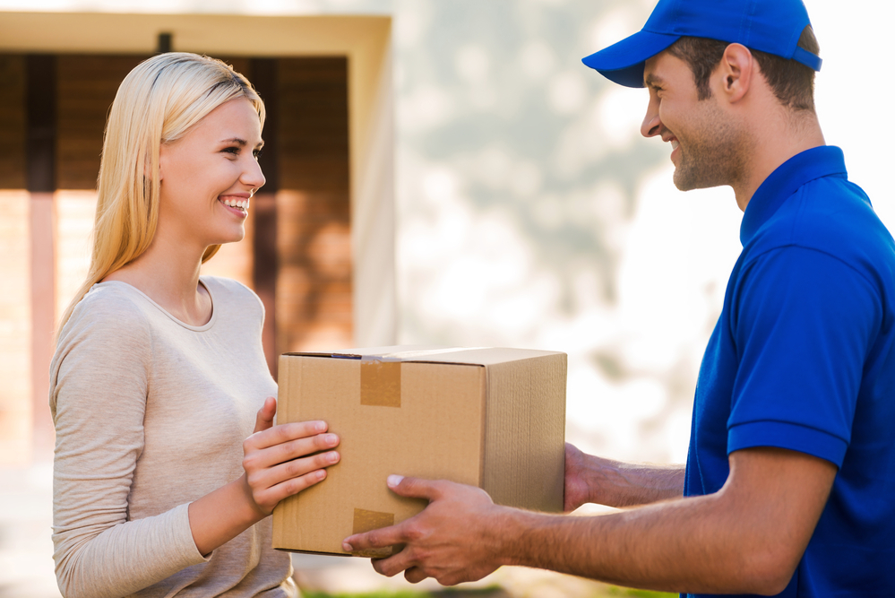 wholesale vitamins. Dropshipping delivery man handing brown box to a customer.