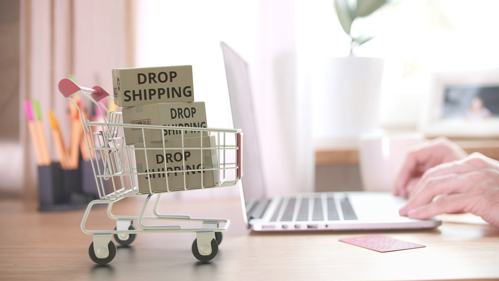 dropshipping boxes in a shopping cart next to laptop. How dropshipping food works.