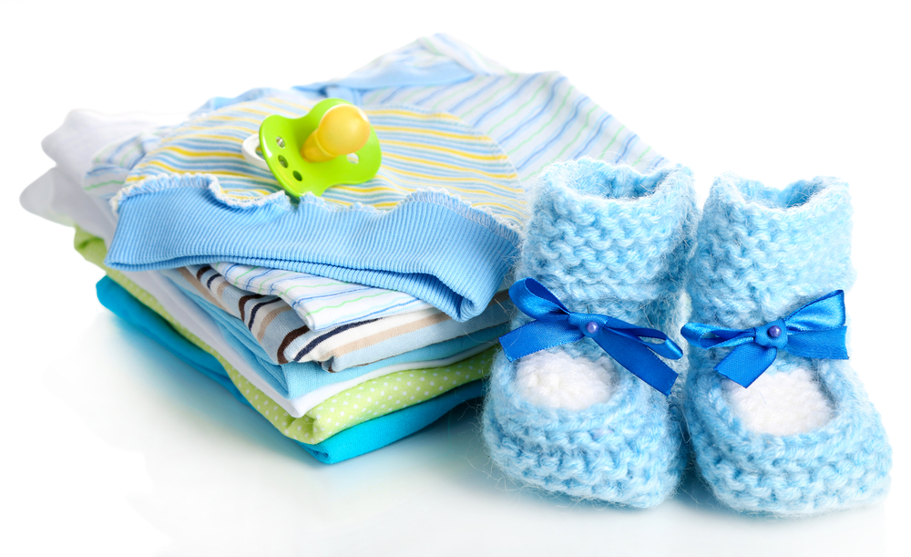 baby clothing and booties against white background.