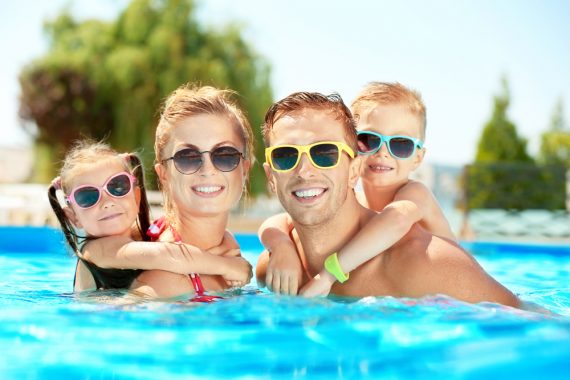 happy family is pool wearing sunglasses in summer