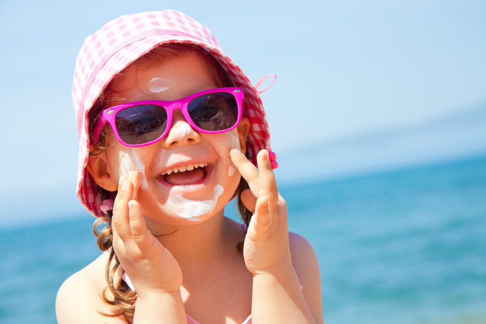 Young girl applying sunscreen to her face. summer dropshipping trends.