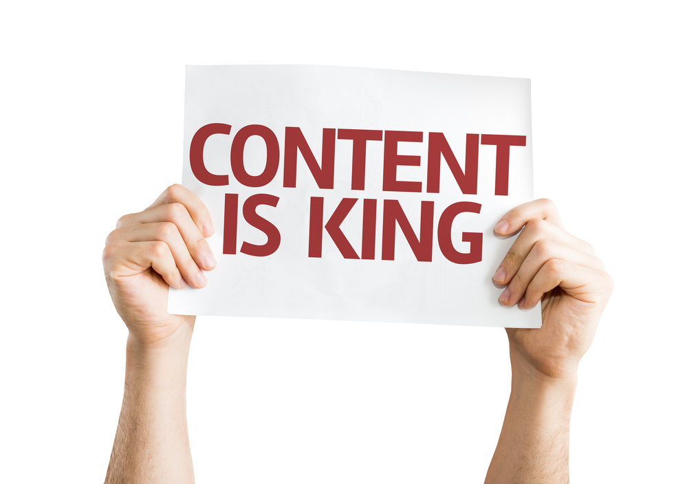 man holding a sign that reads content is king
