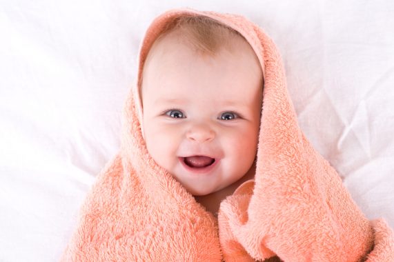 A cute baby wrapped in an orange towel