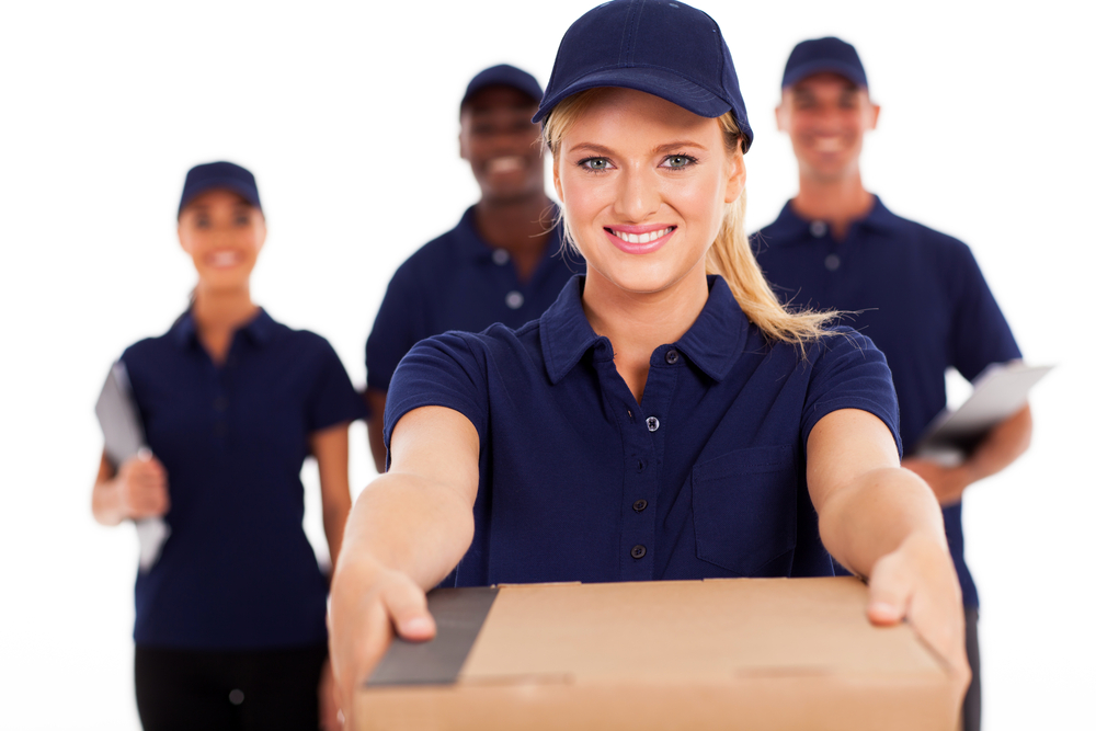 young delivery woman presenting dropshipping package with colleagues