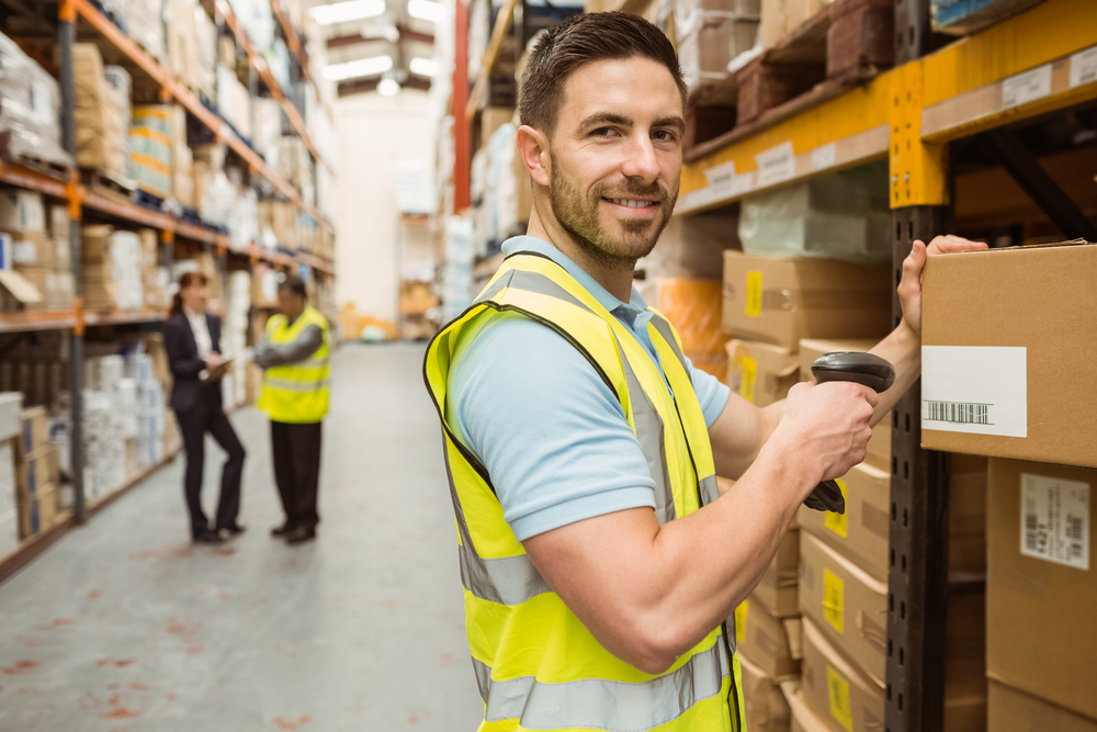 Man working in dropshipping warehouse labeling packages for shopping