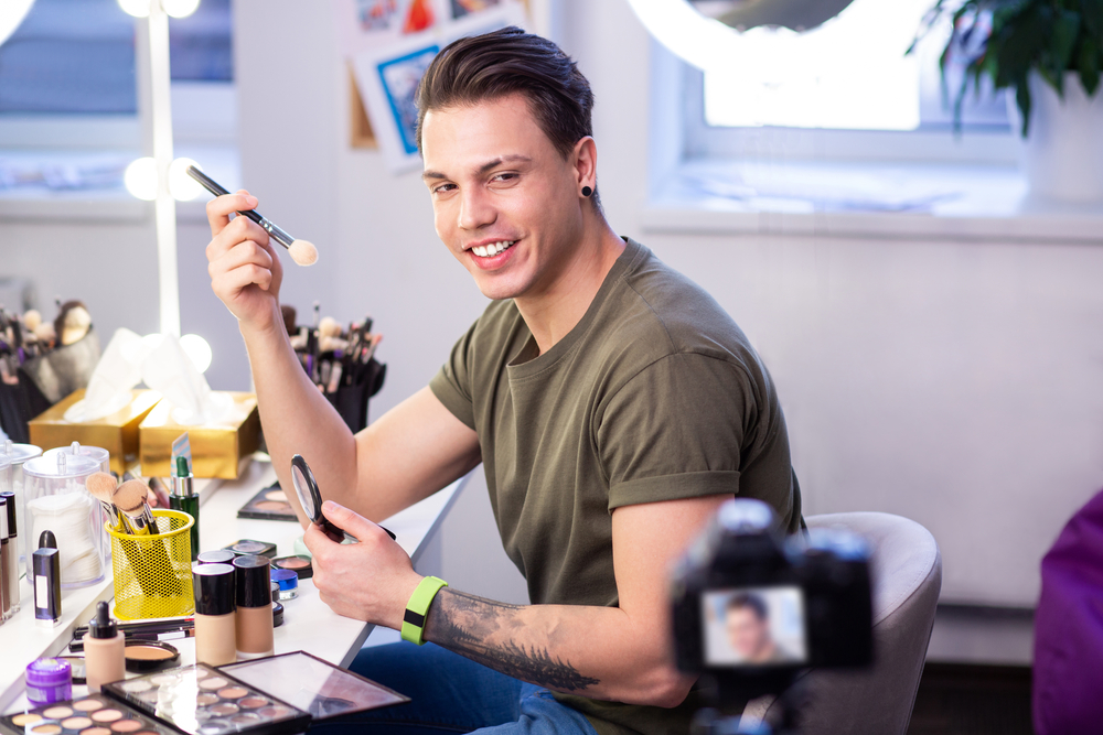 man creating a video ad for makeup showing how to use the products