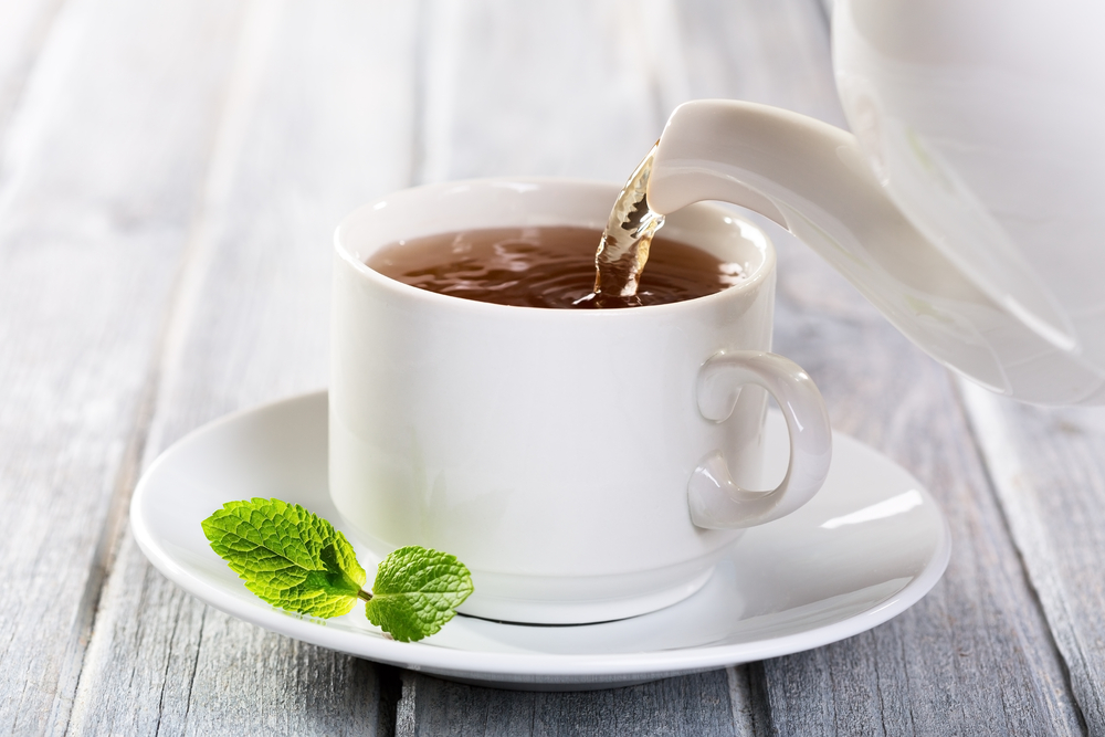 Pouring black tea into a cup